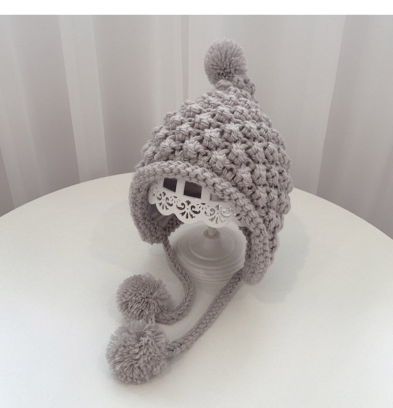 Crochet pixie hat with poms